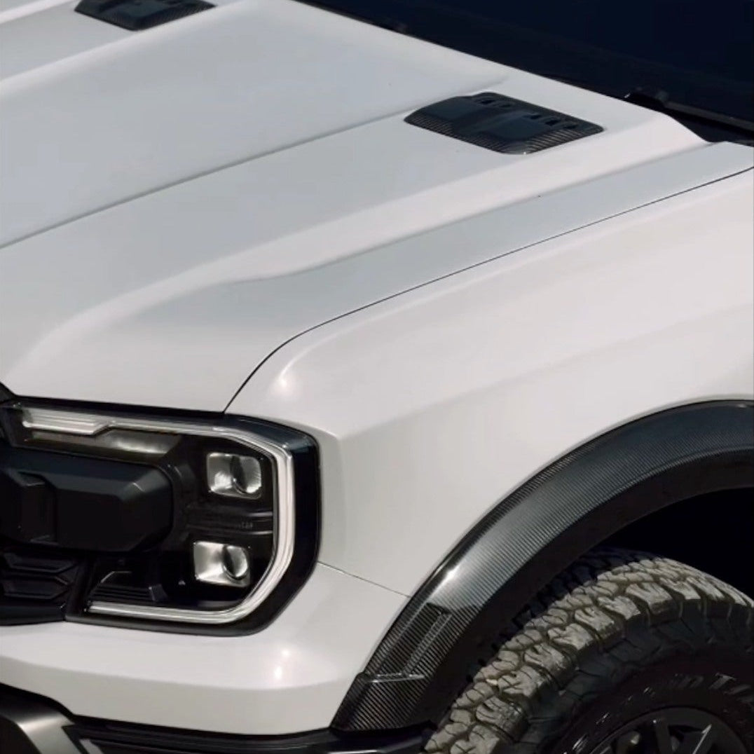 Close-up of a white truck with black accents on a grassy background